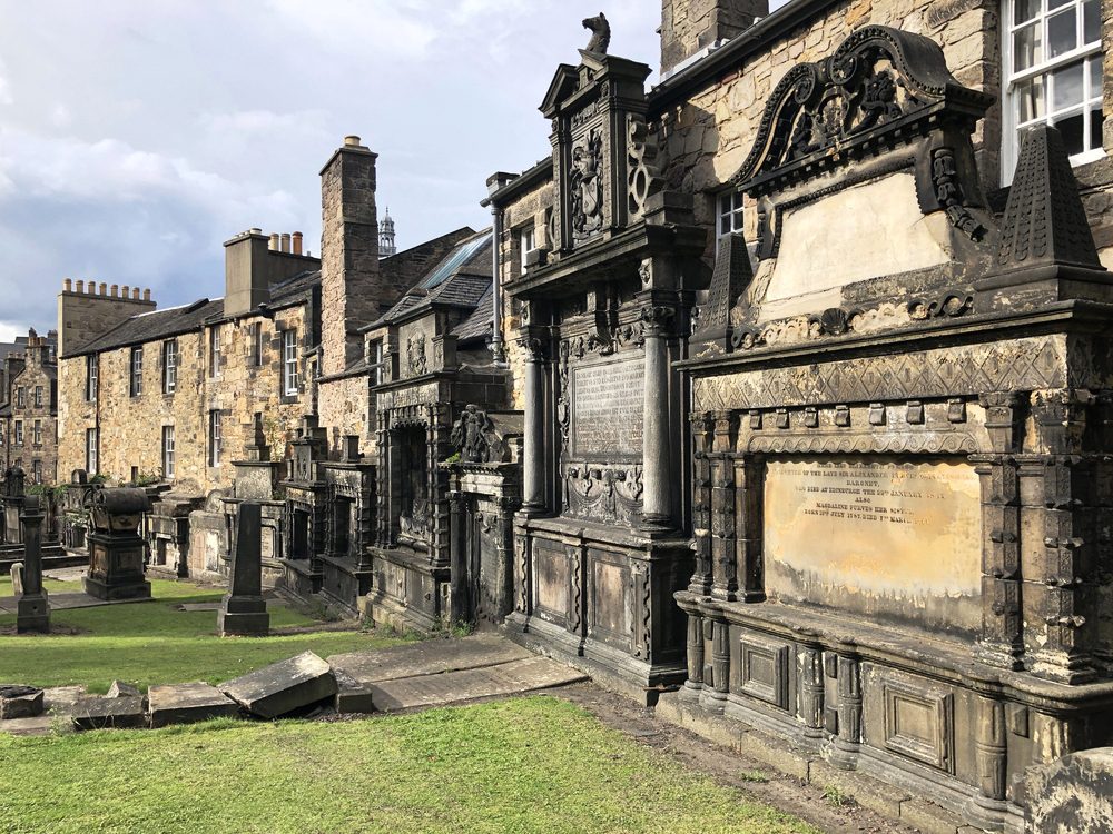 Grey Friars kirkyard an ancient cemetery in Edinburgh where old stones are leaned against a medieval wall
