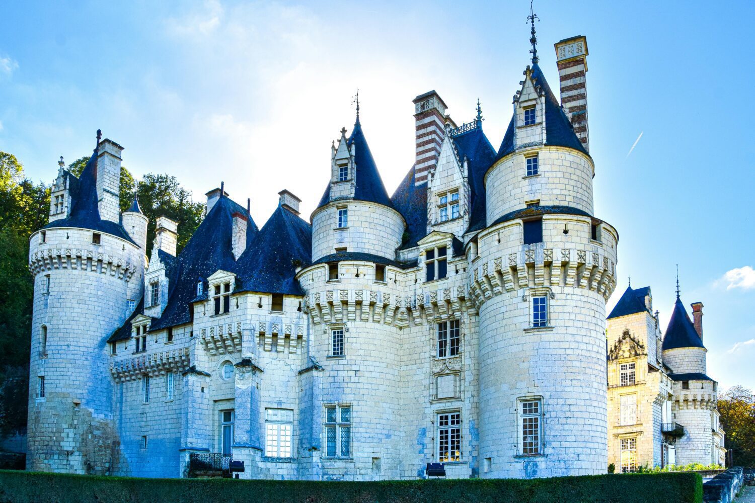 The fairytale castle with pointed roof towers and white painted stone at Chateau d'Usse