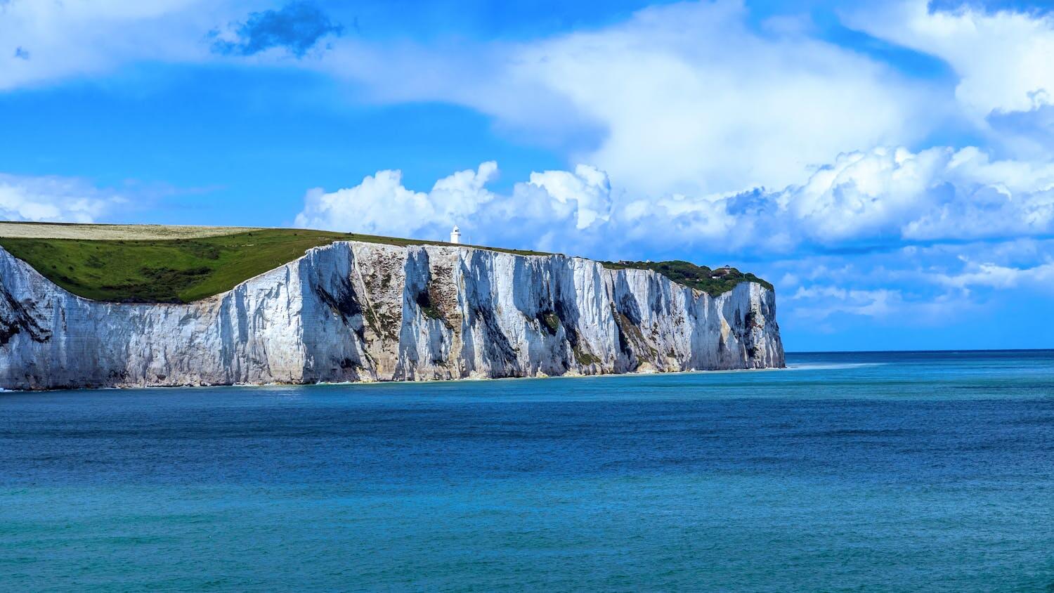 Breathtaking view of the White Cliffs of Dover against a vibrant blue sea and sky.