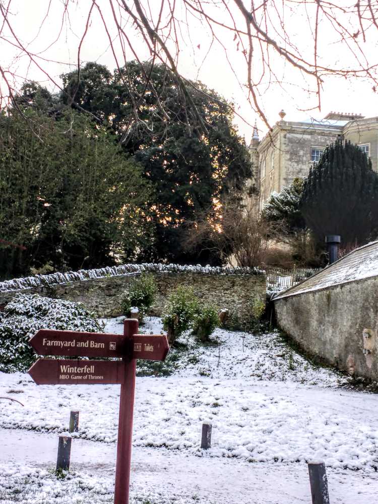 Snow-dusted grounds at Castle Ward, Northern Ireland, with a sign pointing to Winterfell Game of Thrones.