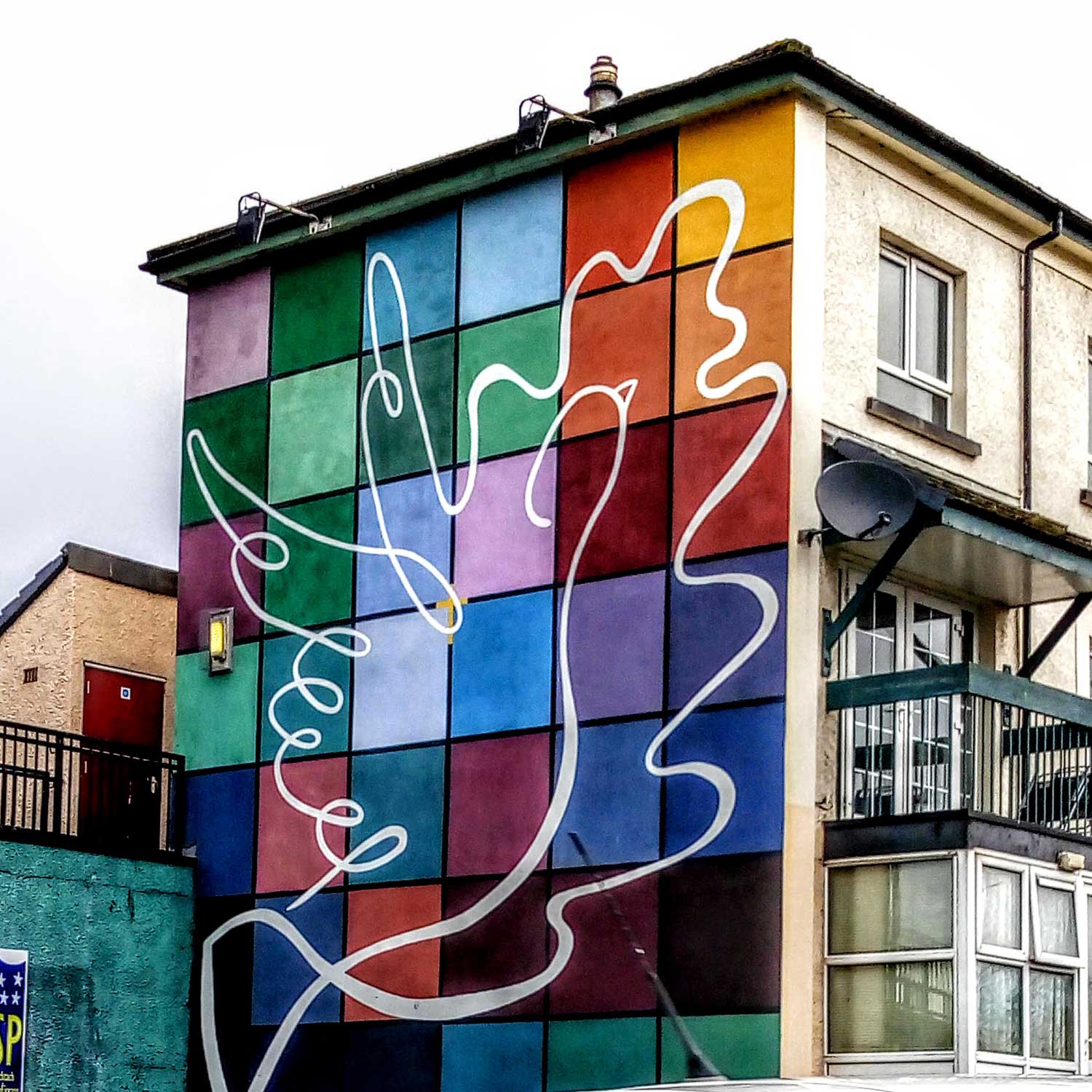 A checkerboard of coloured squares and a white dove of peace outlined on the squares