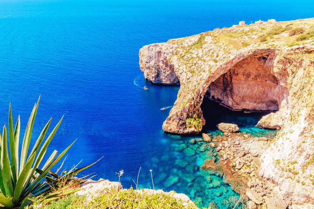 View from above the Blue Grotto in Malta. Bright blue and turquoise sea meats carved caves