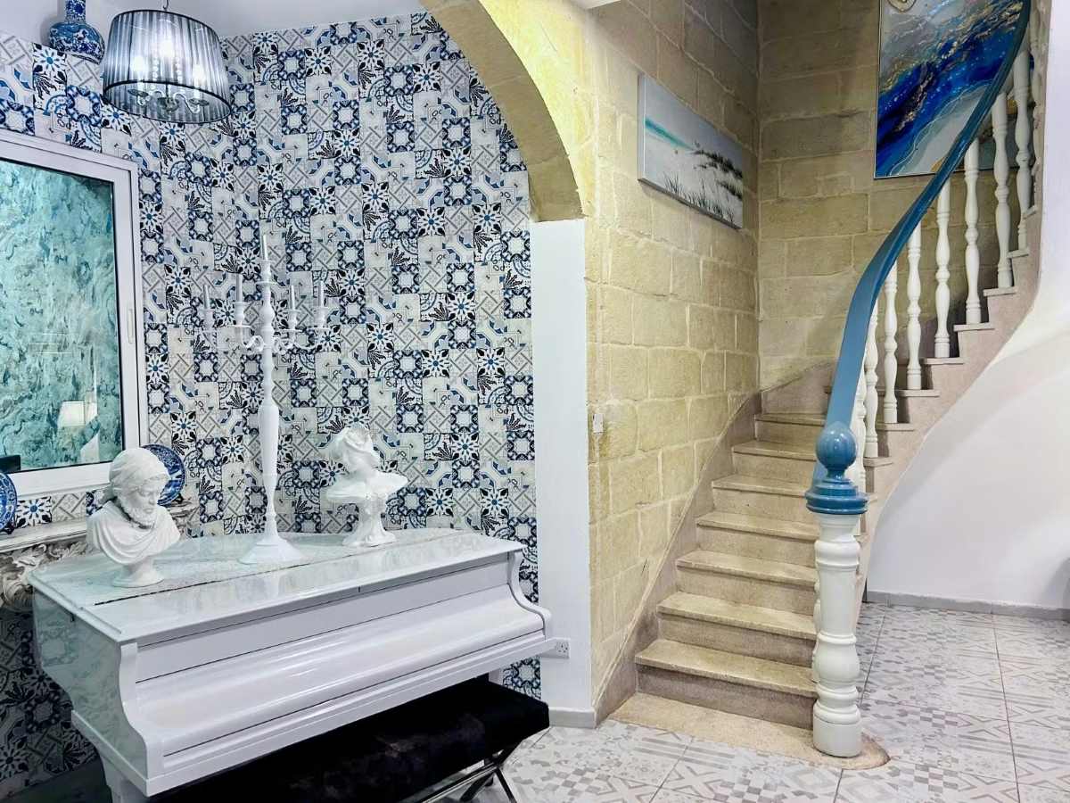 A white baby grand piano sits in the Casa Birmula in Valletta