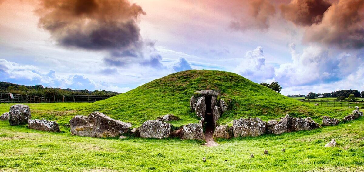 Bryn Celli Ddu burial chamber in Wales. A court tomb mound covered in grass with a stone entrance