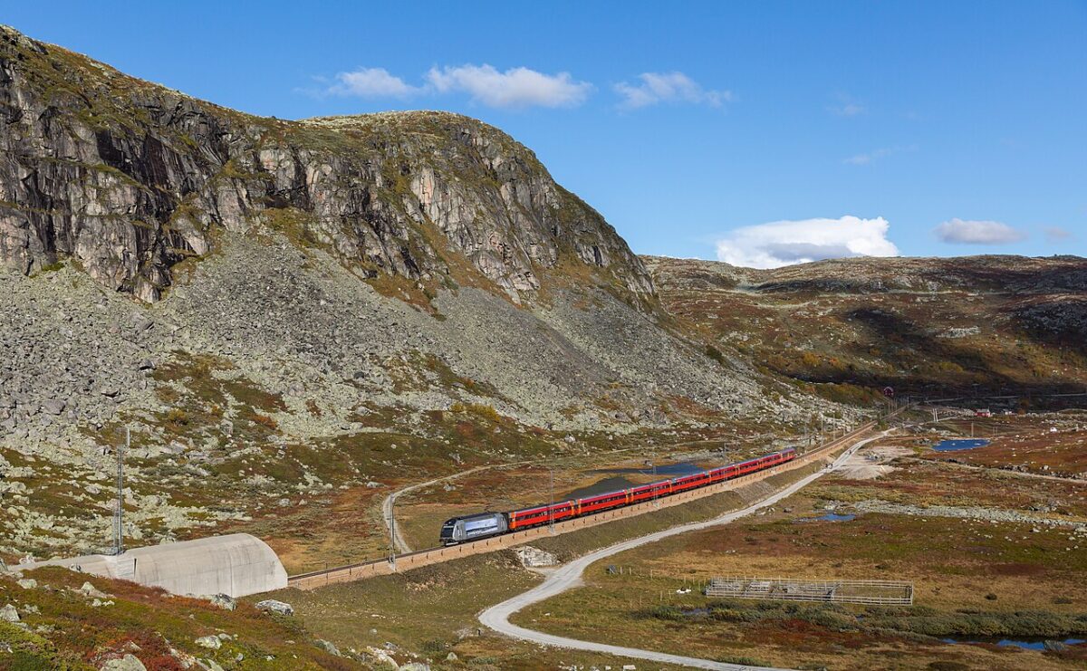 Bergen train line with large rocky mountain running beside the tracs