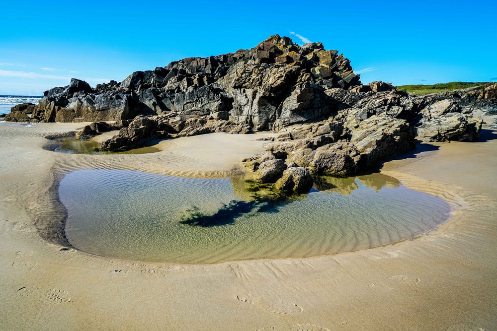 Tramore Beach with a large rock and a water pool