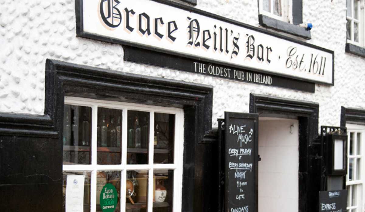 Grace Neills Bar, the oldest pub in Ireland, with a white textured facade and black trim.