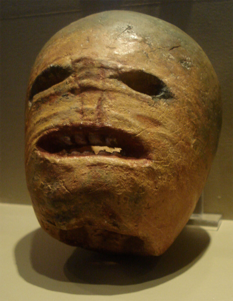 Traditional carved Irish turnip lantern with a grimacing face and hollow eyes.