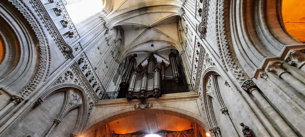 The grand interior of Durham Cathedral showcases its magnificent pipe organ and intricate Gothic architecture.