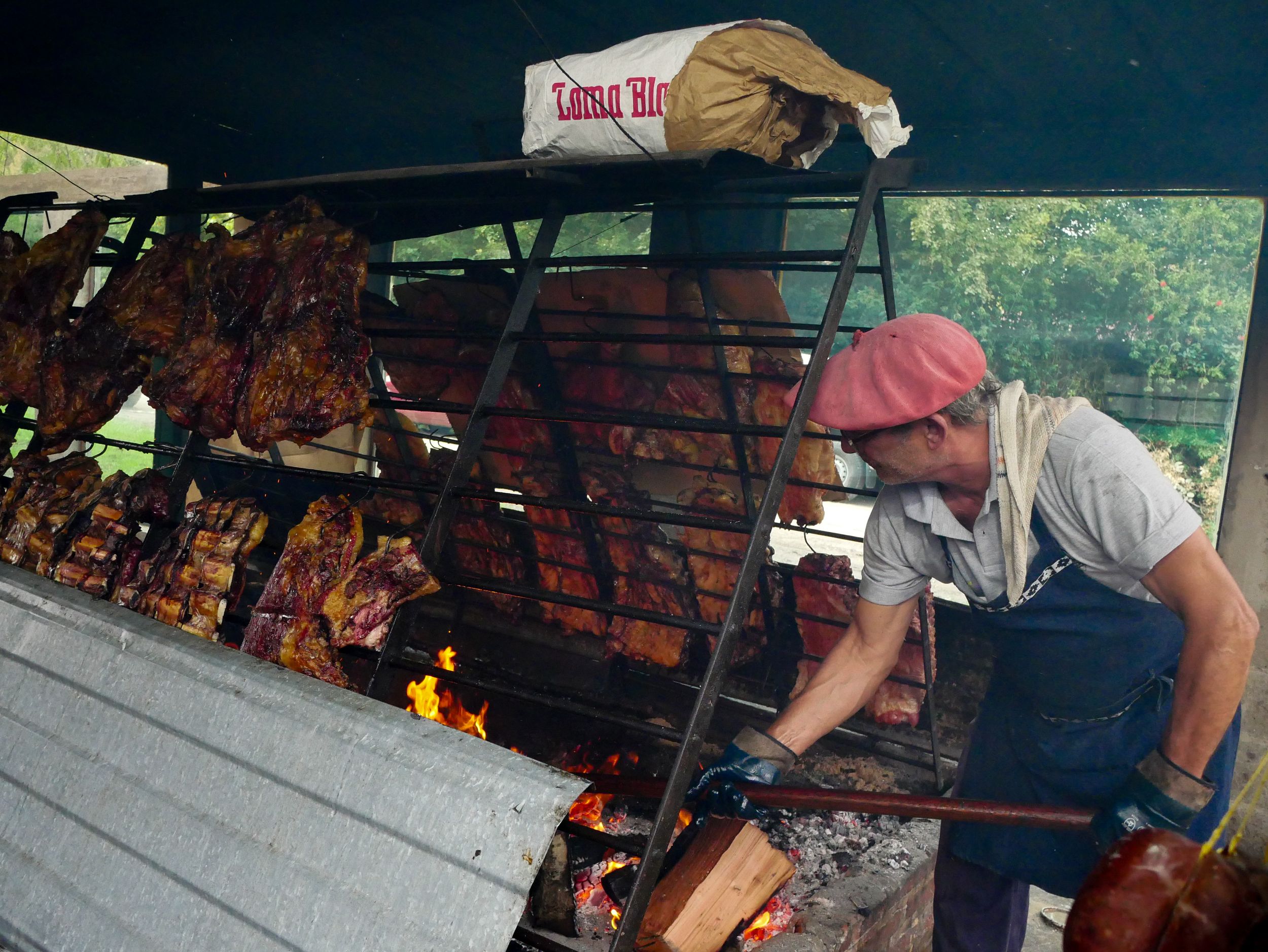 Argentine gaucho preparing asado grill with meats in Uribelarrea, capturing cultural heritage.