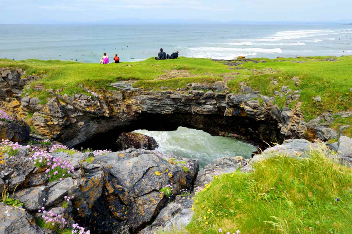 Fairy Bridges with a deep well under the bridge where the waves crash and people sitting on top of the bridge watching the ocean