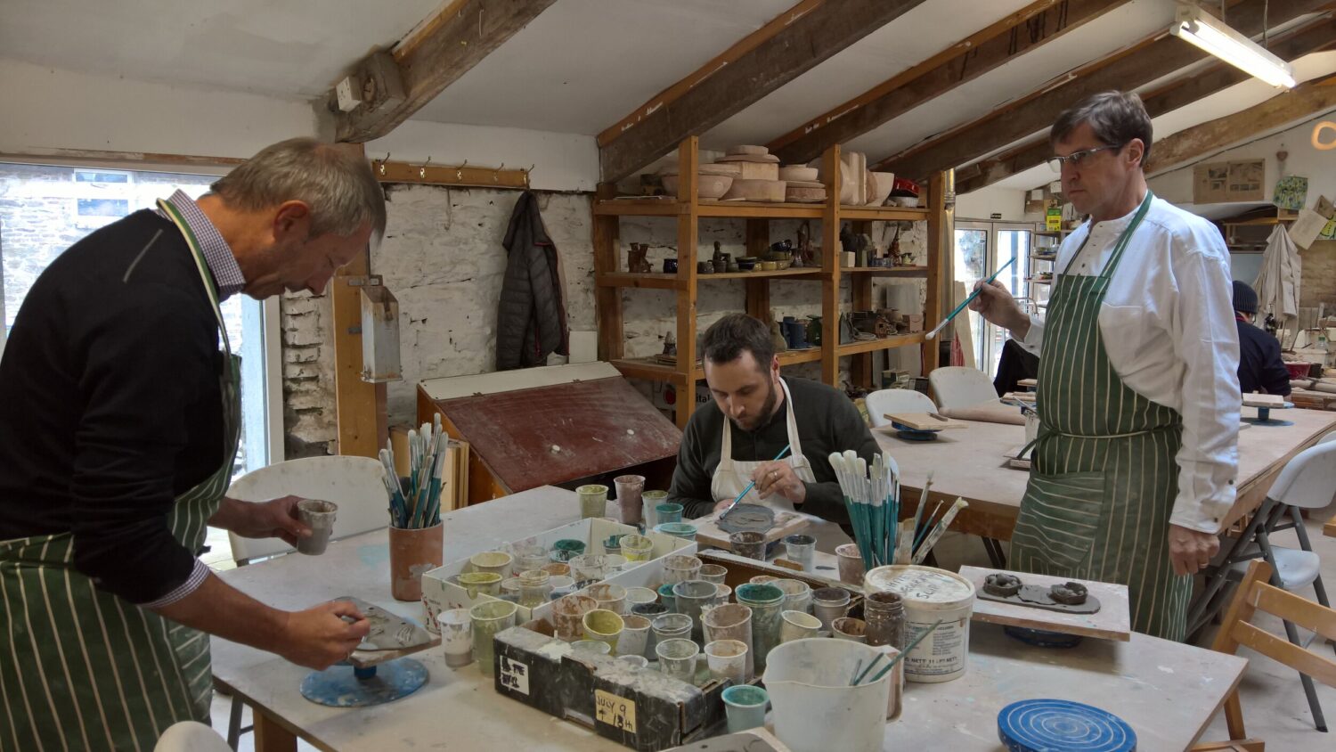 The Kinsale Pottery a man is colouring some ceramic ware in the school