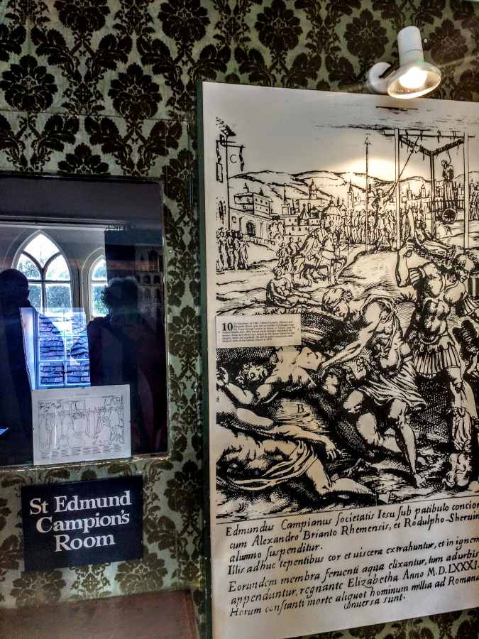 A sign reading St Edmund Campions Room is mounted next to a historical print depicting a public execution.