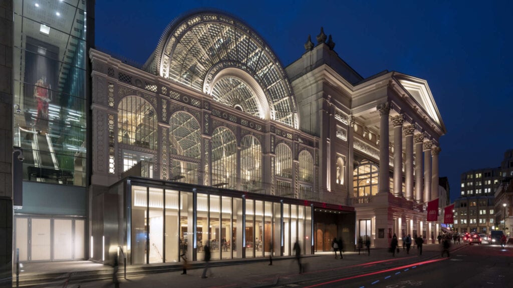 The Royal Opera and Royal Ballet company building at the Covent Garden Market slit up at night so you  can see the spectacular Victorian glass works