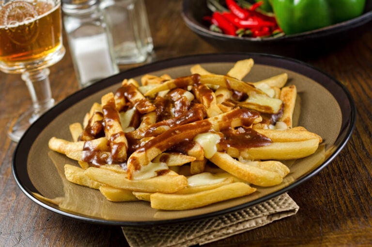 A plate of delicious poutine with french fries, gravy, and cheese curd.