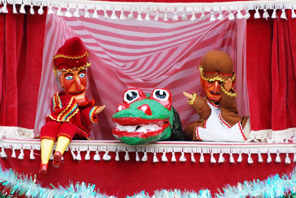 a Punch and Judy show at Covent Garden Market, set in a small red and white curtained booth with both Punch and Judy and the Dragon